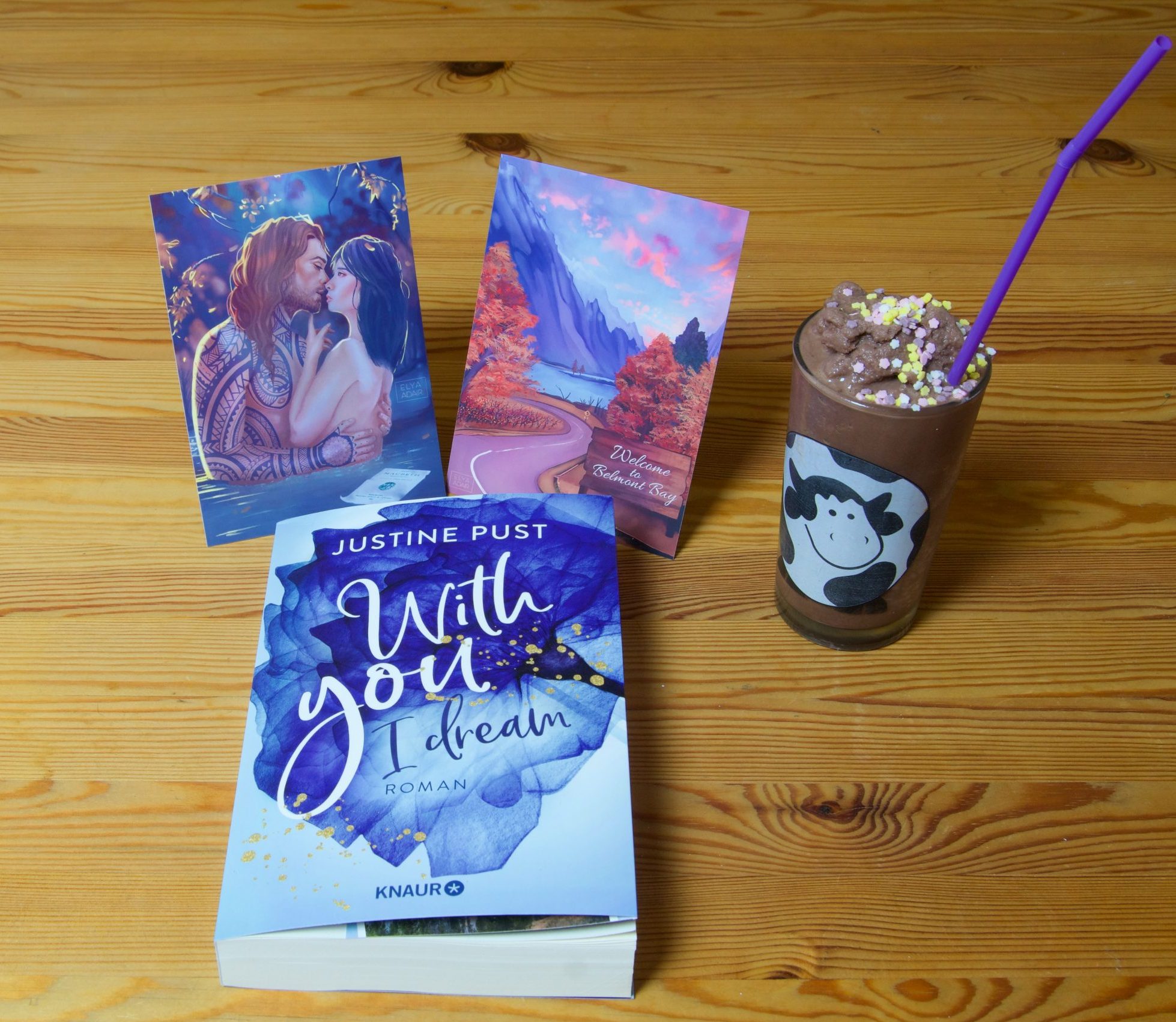 Buch "With you I dream" von Justine Pust mit 2 Motivkarten und ein Glas Milch-Shake mit Kuh-Motiv