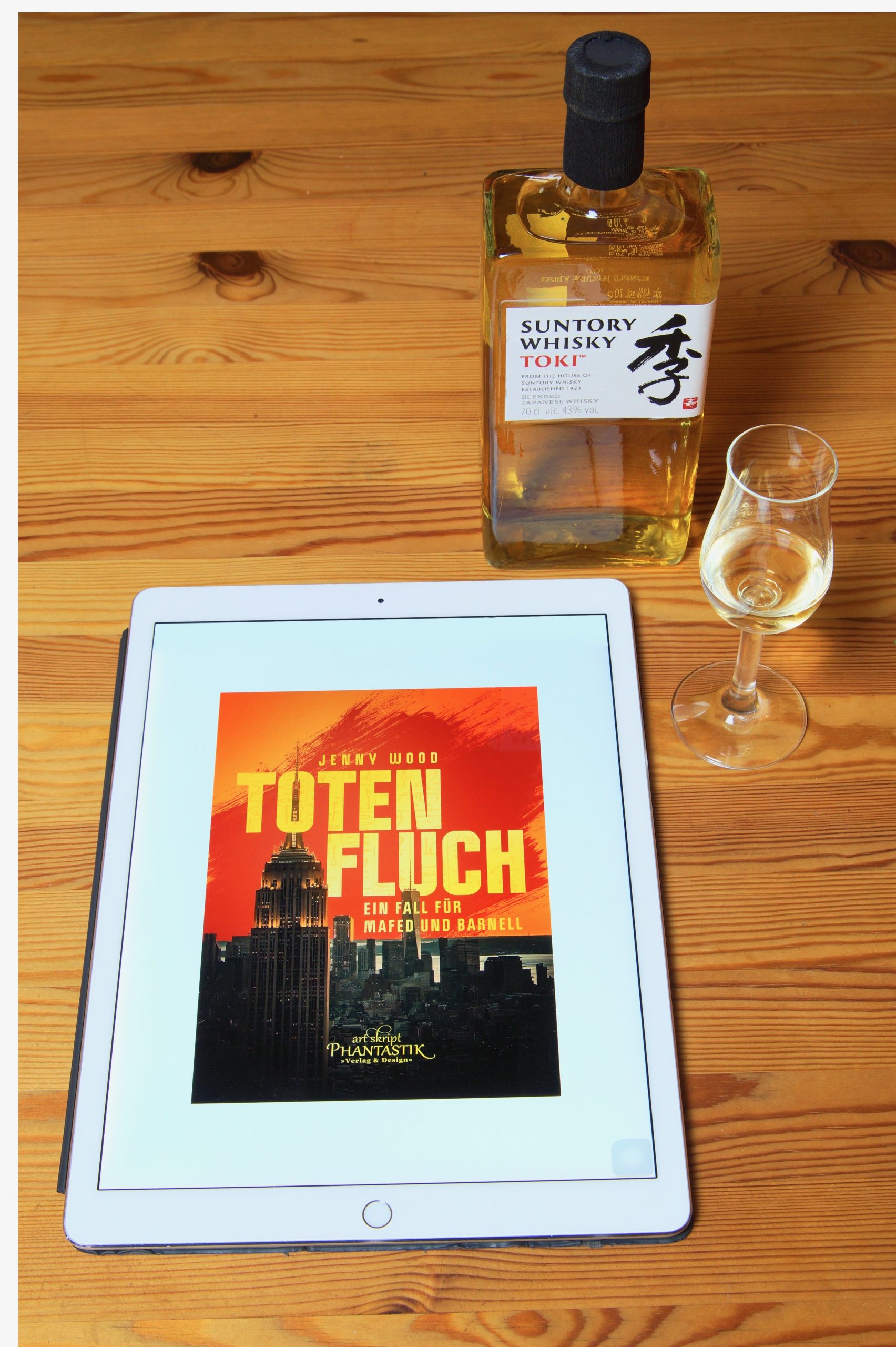 Eine Flasche TOKI Blend Whisky von Suntory nebst Glas und ein Ipad mit dem Cover von Totenfluch